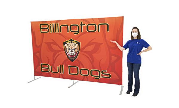 photo of woman wearing a face mask standing next to ten foot long renovate partition with bull dog head graphic and Billington bull dogs