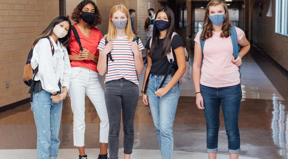 photo of five high school girls wearing face masks in school hallway